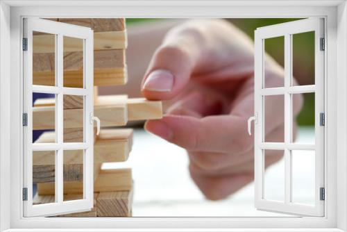 Fototapeta Naklejka Na Ścianę Okno 3D - Closeup of asian man's hand playing wood blocks stack game ,Planning, risk and strategy of project management in business background concept.