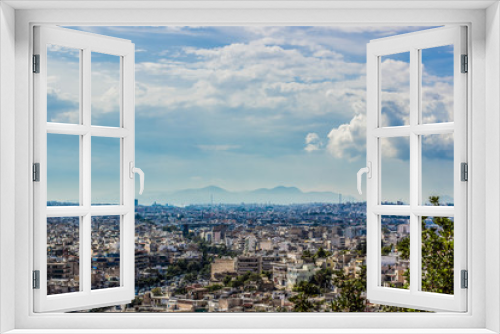 beautiful dramatic foreshortening of big old city from above with horizon view to silhouette of big mountain nature scenery landscape in foggy weather, copy space 