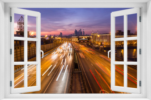 Fototapeta Naklejka Na Ścianę Okno 3D - Road at night with the lights from many cars on the background of the metropolis.