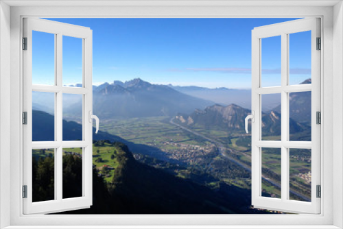 Fototapeta Naklejka Na Ścianę Okno 3D - view from a high alpine mountain peak in Switzerland with a great view of the valleys and villages below and hazy mountains behind