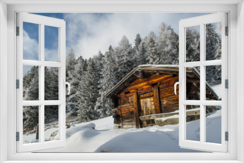 Fototapeta Naklejka Na Ścianę Okno 3D - an old wooden cottage in a snow covererd landscape in  the swiss alps