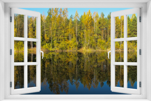 Fototapeta Naklejka Na Ścianę Okno 3D - Autumn forest with a beautiful lake in sunny day. Bright colorful trees reflecting in calm water of the lake.
