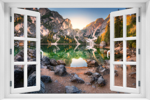 Fototapeta Naklejka Na Ścianę Okno 3D - Stones on the coast of Braies lake at sunrise in autumn in Dolomites, Italy. Landscape with mountains, water with reflection, trees in fall. Travel in italian alps. Dolomiti. High rocks and lake