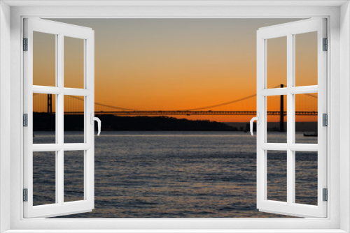 Fototapeta Naklejka Na Ścianę Okno 3D - Sunset view of Tagus river (Rio Tajo) and 25th of April Bridge (Ponte 25 de Abril). Lisbon, Portugal