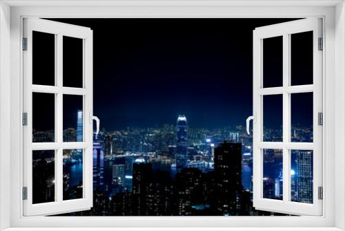Fototapeta Naklejka Na Ścianę Okno 3D - Blick auf die Stadt Hong Kong, China die den Nachthimmel nachts blau färbt