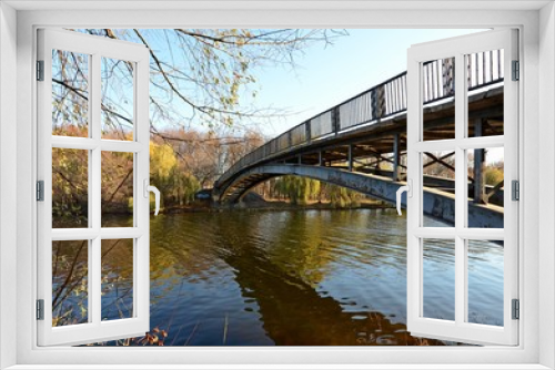 Fototapeta Naklejka Na Ścianę Okno 3D - Arched bridge over the river, reflection of the bridge in the water