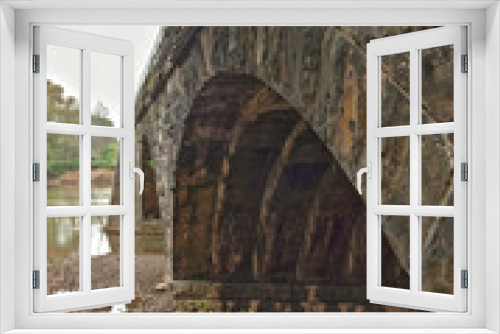 Fototapeta Naklejka Na Ścianę Okno 3D - A skewed arch stone bridge in Western Pennsylvania stretching across a river.