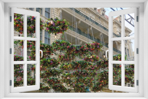 Fototapeta Naklejka Na Ścianę Okno 3D - Blumendeko in der Stadt, Hängende Blumenkränze