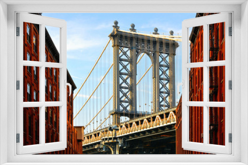 Fototapeta Naklejka Na Ścianę Okno 3D - Manhattan Bridge and red brick wall old  buildings and architectures with windows and blue cloudy sky in Brooklyn in DUMBO district, Manhattan, New York City, USA