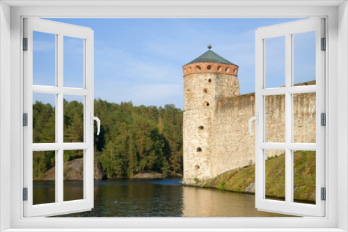 Fototapeta Naklejka Na Ścianę Okno 3D - The tower of the medieval fortress Olavinlinna close up against the backdrop of the coast. Savonlinna, Finland