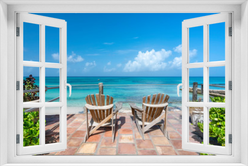 Fototapeta Naklejka Na Ścianę Okno 3D - Wooden chairs facing the clear tropical ocean, summertime concept