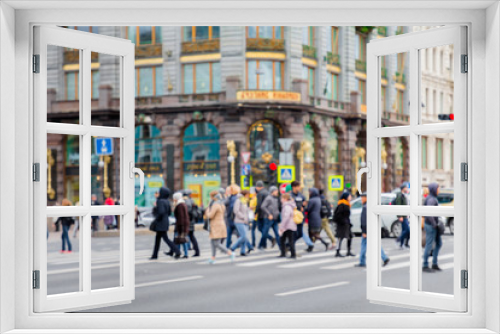 Fototapeta Naklejka Na Ścianę Okno 3D - in the blur of the intersection where a group of people cross the street on the background of the building