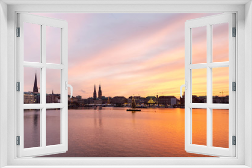 Fototapeta Naklejka Na Ścianę Okno 3D - Sunset in Hamburg. Panoramic view of the decorated city center from Alster Lake, view to Hamburg Rathaus and a christmas tree installed in the center of the lake. Atmosphere before the New Year.