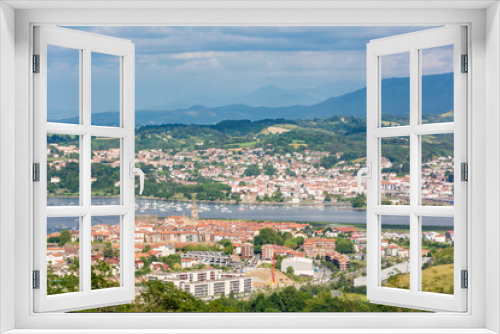 Distant view of typicall fishermen village of Hondarribia, and Henday in the Basque Country, Spain. With some small fishing boats on the foreground and the medieval tower bell on the background