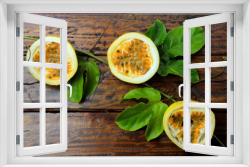 Fototapeta Naklejka Na Ścianę Okno 3D - branches and leaves with yellow passion fruit isolated on wooden table.