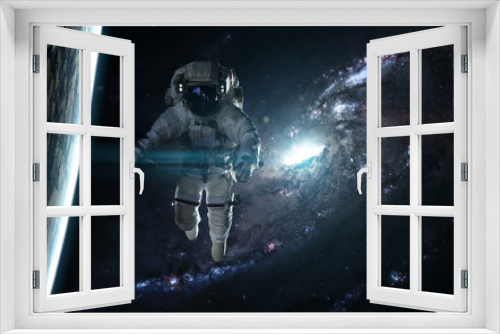 Fototapeta Naklejka Na Ścianę Okno 3D - Astronaut and planet against a blue galaxy. Abstract science fiction. Elements of the image were furnished by NASA