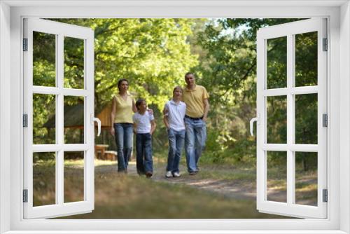 Portrait of happy family of four in autumn park walking