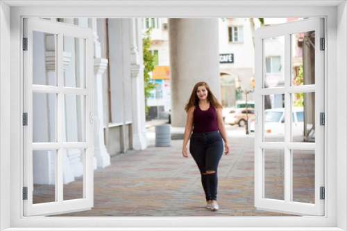 Pretty young woman walking on the city street. Casual fashion, plus size model. xxl women on nature.