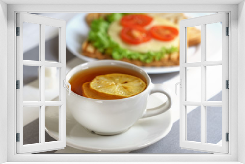 Fototapeta Naklejka Na Ścianę Okno 3D - Fresh, tasty breakfast with a sandwich and tea on a light background.