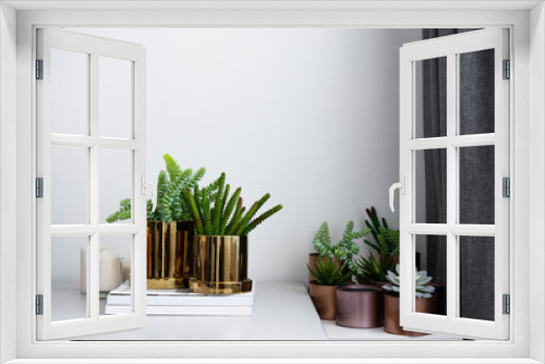 Fototapeta Naklejka Na Ścianę Okno 3D - Composition of gold mirror ceramic pots with artificial plants inside setting on minimal books and group of copper aluminium pots in natural light setting scene / cozy interior concept / decoration 