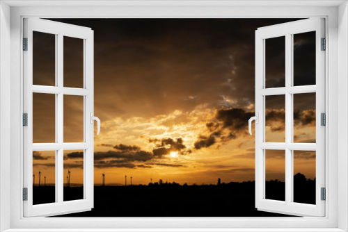 Fototapeta Naklejka Na Ścianę Okno 3D - Dramatischer Himmel bei zentriertem Sonnenaufgang in Orange und Gelbtöne