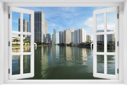 Fototapeta Naklejka Na Ścianę Okno 3D - Miami, Florida 09-08-2018 Buildings of the City of Miami and Brickell Key and their reflections on the tranquil water of Biscayne Bay.