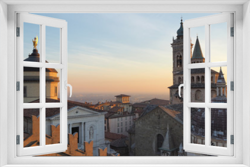 Fototapeta Naklejka Na Ścianę Okno 3D - Bergamo, Italy. The old town. Aerial view of the Basilica of Santa Maria Maggiore and the dome of the cathedral during the sunset. In the background the Po plain