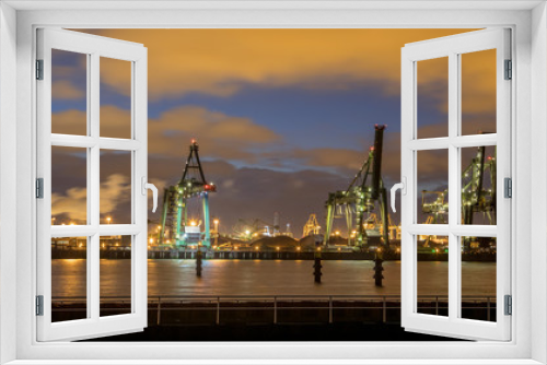 Industrial Harbor quay with loading cranes at night