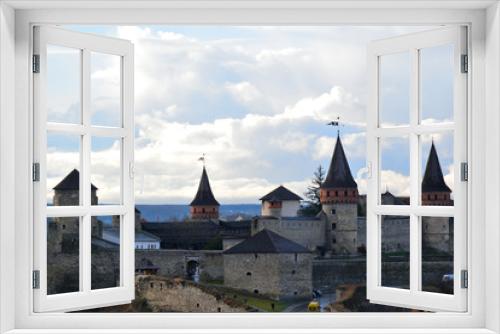 Fototapeta Naklejka Na Ścianę Okno 3D - View of the medieval fortress Kamenets-Podolsk. Gray stone walls with towers on a background of clouds