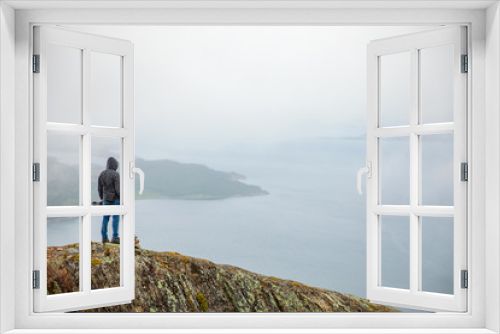 Fototapeta Naklejka Na Ścianę Okno 3D - Young man looking on Panorama of nature view with fjord and mountains in clouds, Norway