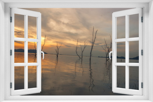 Fototapeta Naklejka Na Ścianę Okno 3D - The background of the trees that stand on the lake or in the natural water source behind the mountains is surrounded and has a beautiful evening sky light, seen during travel.