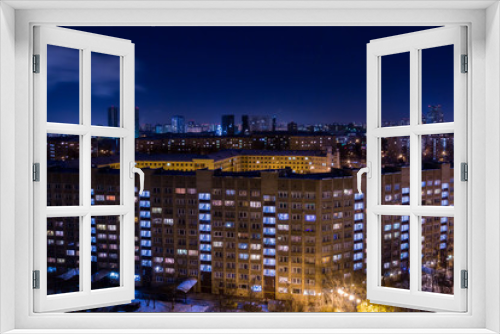Fototapeta Naklejka Na Ścianę Okno 3D - Evening or night city landscape. Lights in the Windows of apartment buildings.