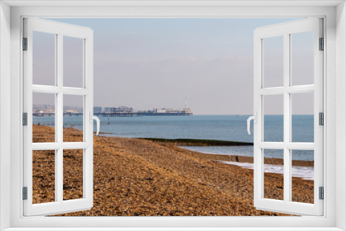 Fototapeta Naklejka Na Ścianę Okno 3D - Looking along the empty beach at Hove towards Brighton Pier, during winter