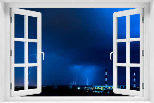 Fototapeta Naklejka Na Ścianę Okno 3D - The cooling towers of thermal power station in the rainy night during the storm with the lightning