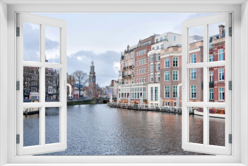 Fototapeta Naklejka Na Ścianę Okno 3D - The Mint tower (Munttoren) with the Amstel river in Amsterdam, the Netherlands, view from Halvemaansbrug bridge.