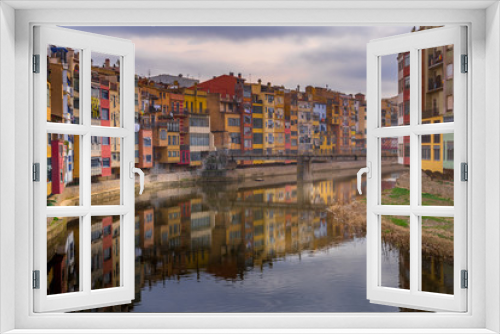Fototapeta Naklejka Na Ścianę Okno 3D - Colorful yellow, red, green houses alongside the Onyar river with reflection on the water in Girona Catalonia region Spain