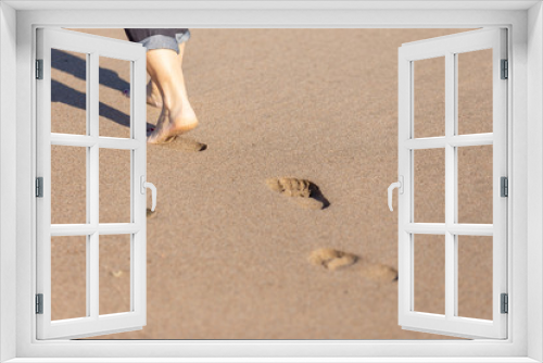 Fototapeta Naklejka Na Ścianę Okno 3D - footprints of a woman walking barefoot on the sand