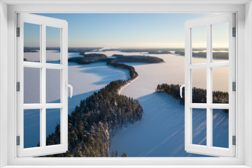 Fototapeta Naklejka Na Ścianę Okno 3D - Aerial winter landscape of ridge road at frozen lake