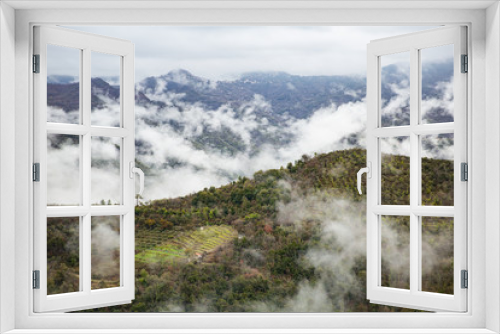 Fototapeta Naklejka Na Ścianę Okno 3D - Panoramic top view of Alps mountains in fog and clouds, valley with clouds. Medieval buildings of Perinaldo town, Liguria, Italy