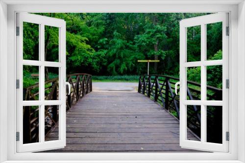 Fototapeta Naklejka Na Ścianę Okno 3D - A small arched footbridge spans a creek along the greenway at Shelley Lake Park in Raleigh North Carolina.