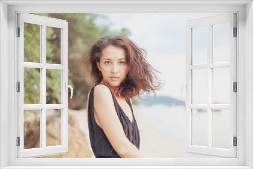 Portrait of a beautiful young woman with dark hair, on the beach, sensual portrait, natural beauty