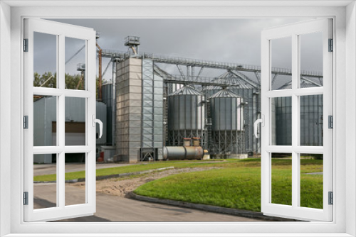Fototapeta Naklejka Na Ścianę Okno 3D - Exterior of Agricultural Silo building with storage tanks for agricultural crops processing plant, drying of grains, rape, wheat, corn, soy, sunflower.