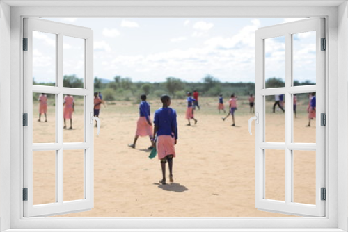 Fototapeta Naklejka Na Ścianę Okno 3D - African children and Caucasian people playing football outside together.