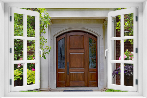 Fototapeta Naklejka Na Ścianę Okno 3D - elegant wooden front door and portico entrance surrounded by flowers of upper class house