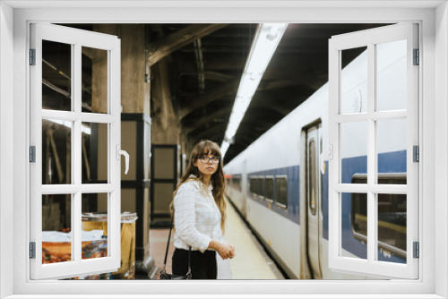 Thoughtful woman waiting for a train at a subway platform