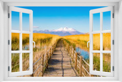 Fototapeta Naklejka Na Ścianę Okno 3D - Wooden bridge walkway path on marshes and reeds in front of mountain. This is from Sultan Sazligi and Erciyes Mountain in Kayseri Turkey. Pastoral beautiful landscape background. 
