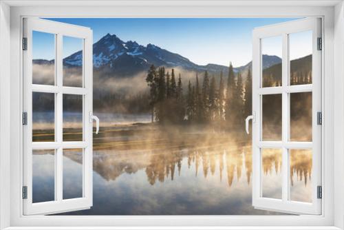 Fototapeta Naklejka Na Ścianę Okno 3D - South Sister and Broken Top reflect over the calm waters of Sparks Lake at sunrise in the Cascades Range in Central Oregon, USA in an early morning light. Morning mist rises from lake into trees. 