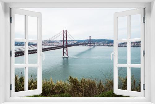 Fototapeta Naklejka Na Ścianę Okno 3D - Panoramic view of Ponte 25 de Abril, long bridge in Lisbon, Portugal