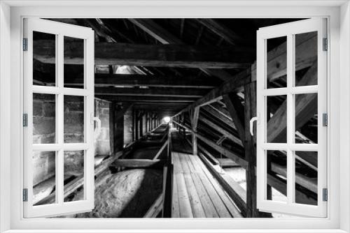 Fototapeta Naklejka Na Ścianę Okno 3D - Wooden structures (rafters and beams) of the attic of an old house. Black and white.