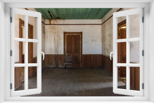 Fototapeta Naklejka Na Ścianę Okno 3D - Three brown wooden doorways in an old farmhouse with wainscoting